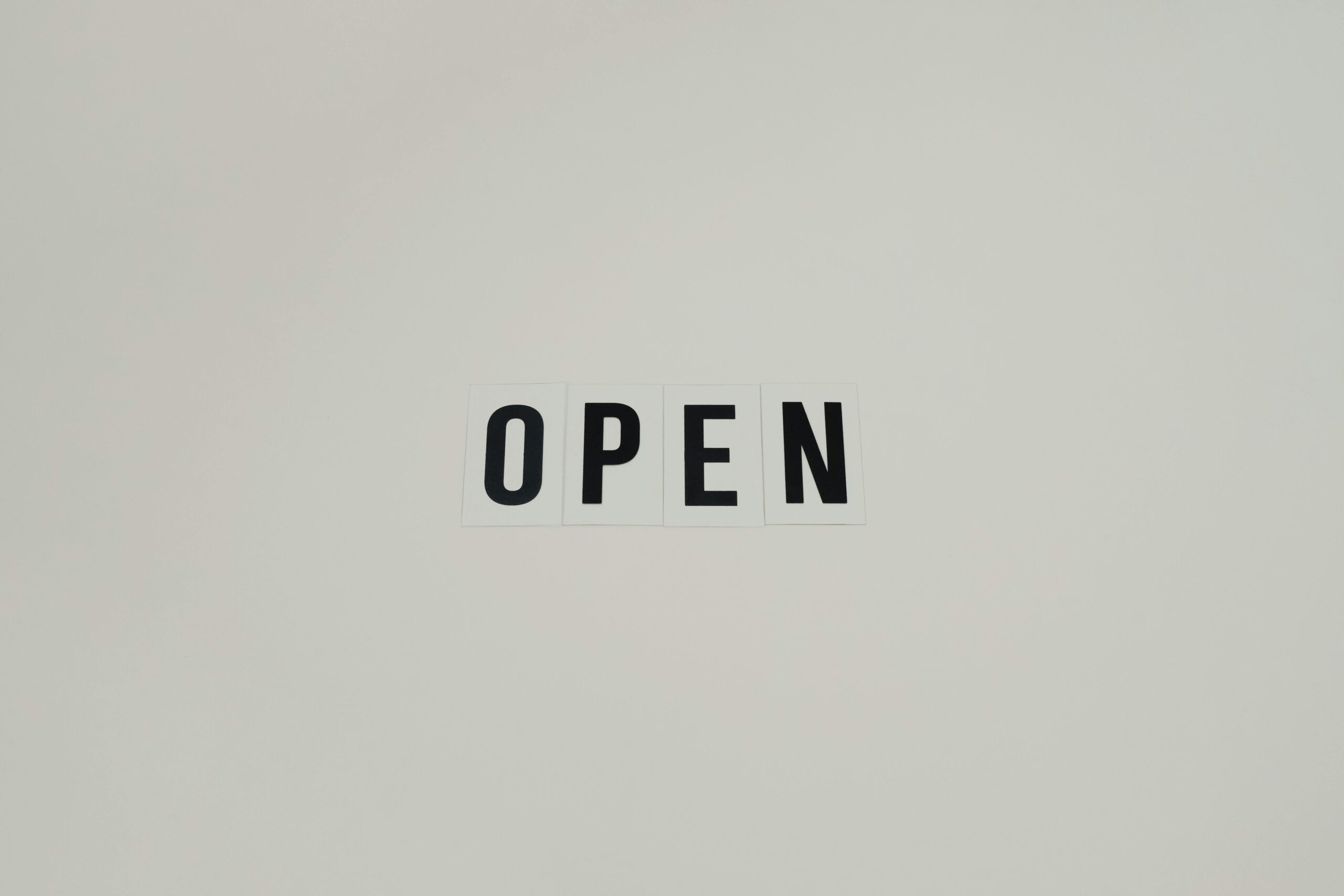Simple and minimalist text reading 'OPEN' on a white background, ideal for business use.