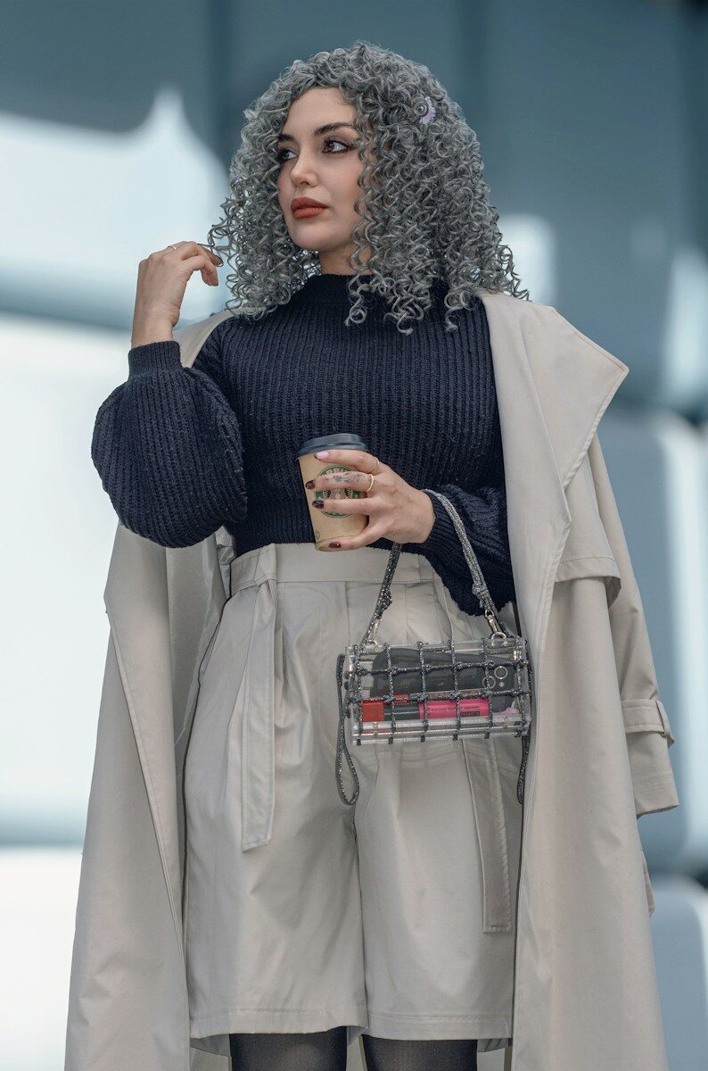 Woman with curly gray hair holding coffee cup